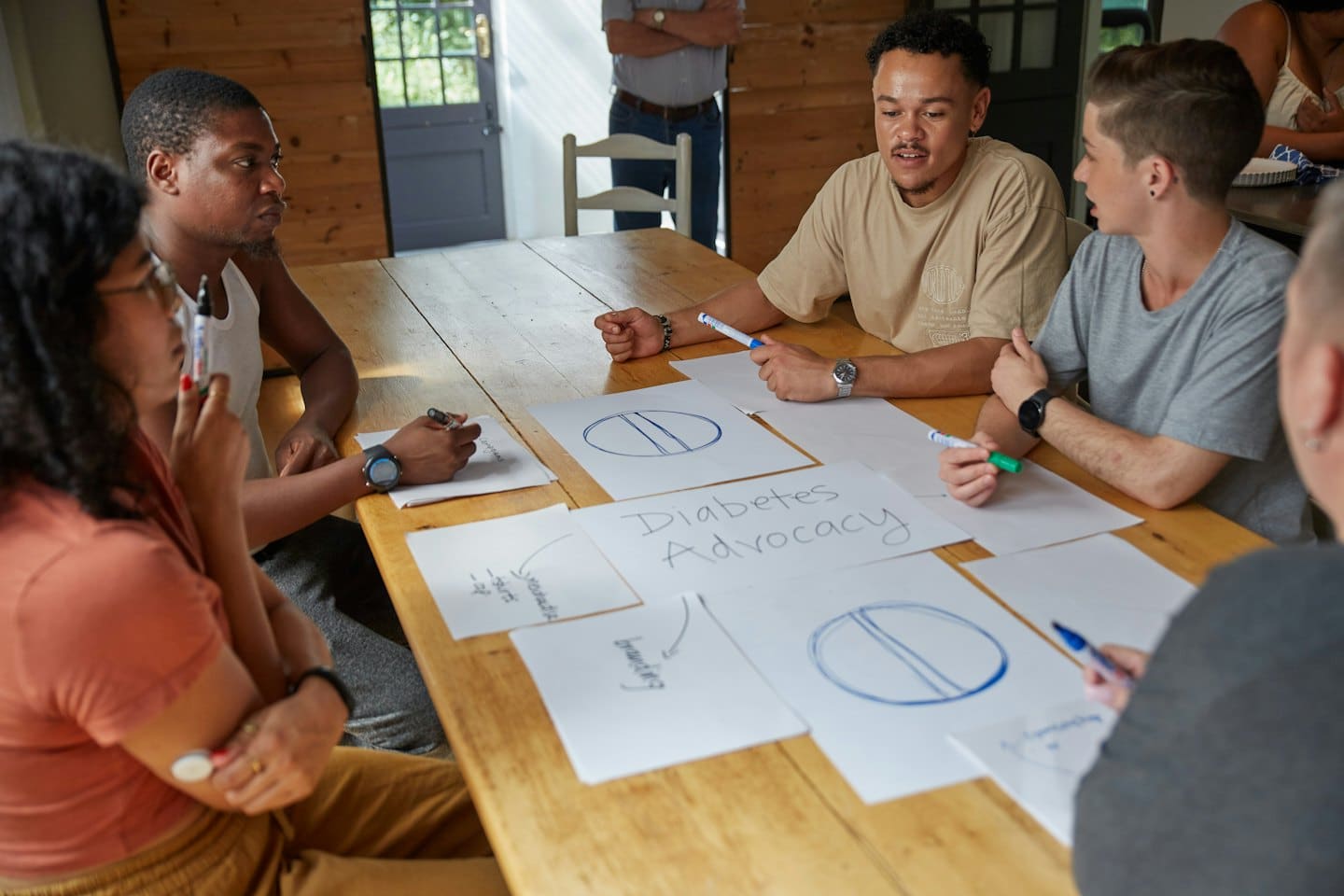 Un team che fa brainstorming di idee attorno a un tavolo di legno rustico.